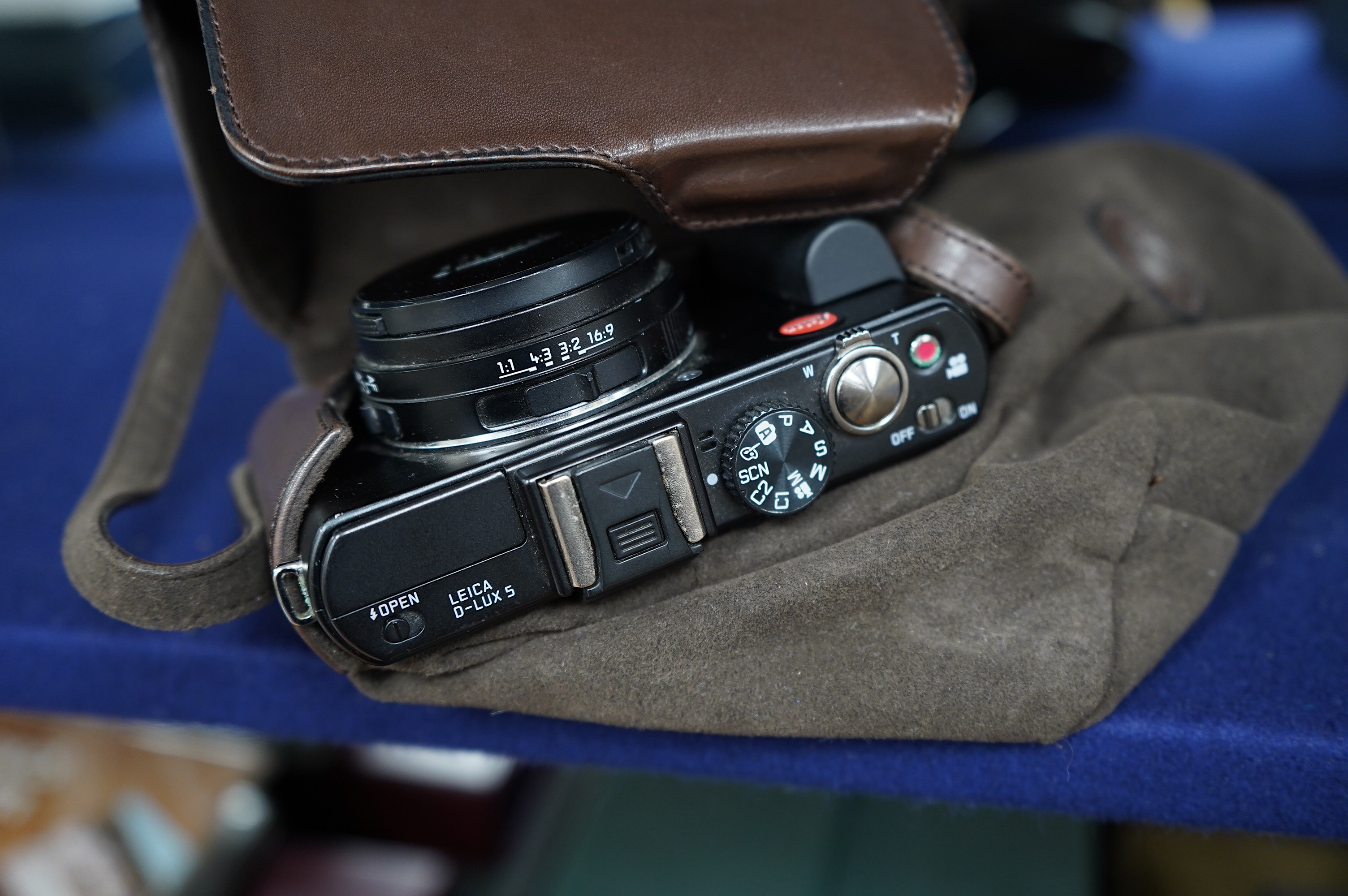 A Leica D-LUX 5 digital camera no.4215221 with leather case, charger and paperwork. Condition - fair to good.